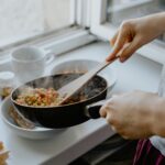 person holding black frying pan